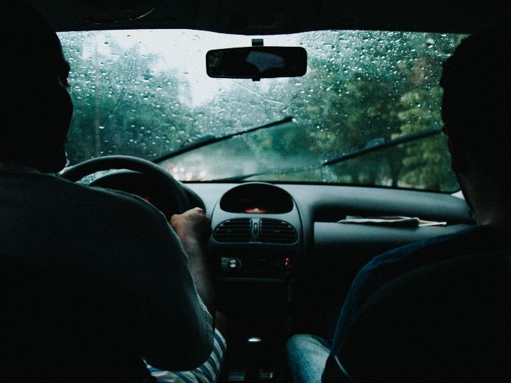 Driver and passenger in the front seats on a rainy day